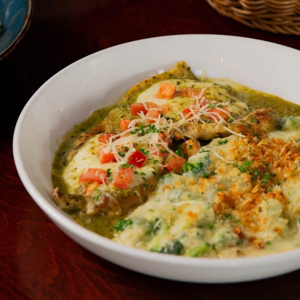 Chicken and broccoli in a creamy green sauce, topped with diced tomatoes and shredded cheese.